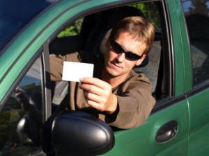 Man showing driver's license while sitting in car
